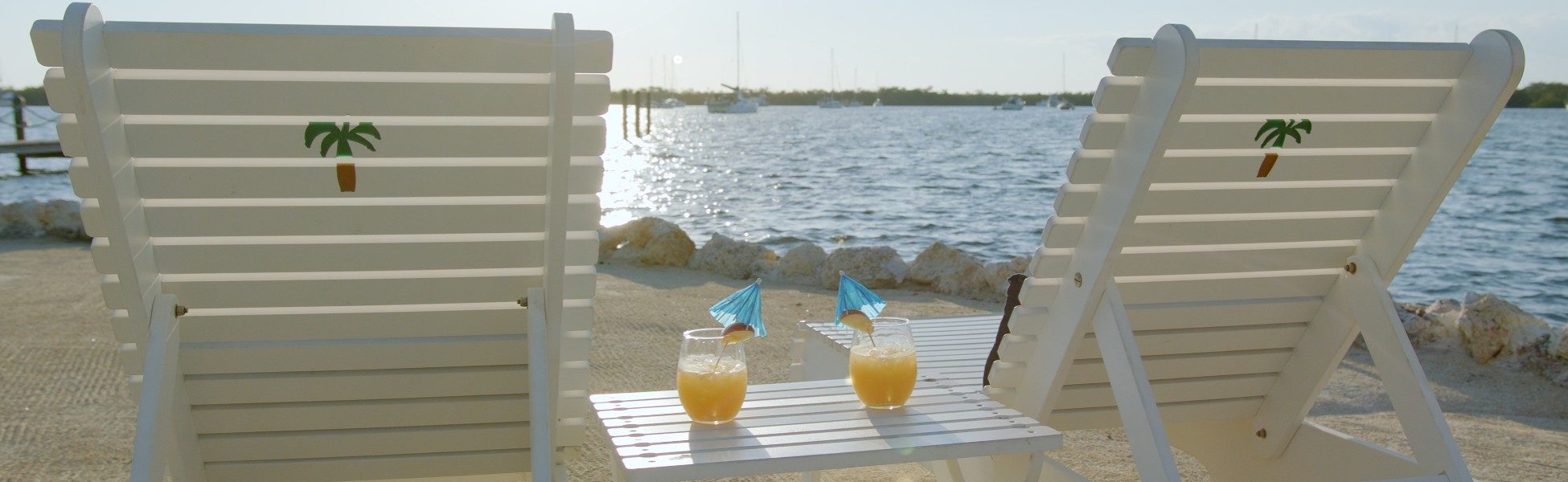 A set of lounge chairs on the private beach at coconut palm inn